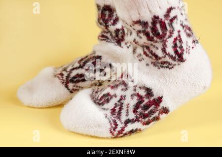 Children's feet in wool socks on a yellow background Stock Photo