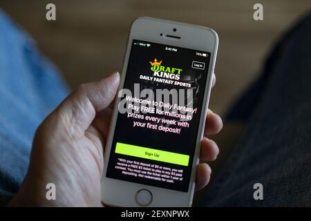 A man opens the DraftKings app from his iPhone on March 3, 2021. DraftKings is an American daily fantasy sports contest and sports betting operator. Stock Photo