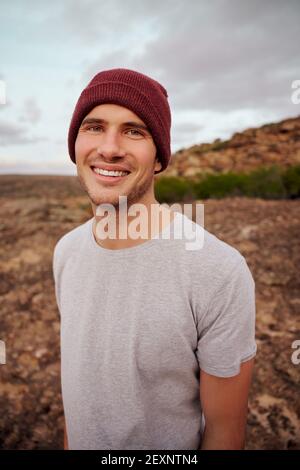 Portrait of smiling male hiker looking at camera standing on mountain Stock Photo