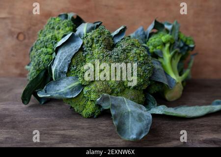 Broccoli on a wooden background. Cabbage, green healthy vegetable. Green leaves. Stock Photo