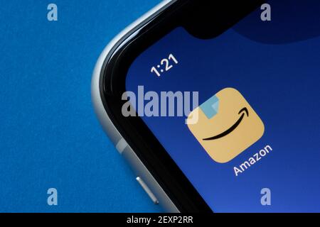 The new Amazon app icon is seen on an iPhone, showing a blue packing tape above Amazon's signature smile-shaped arrow, on March 4, 2021. Stock Photo
