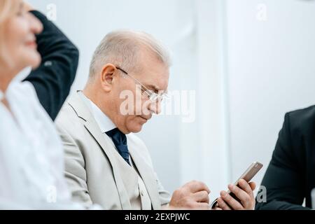close up. serious businessman reading e-mail on his smartphone. Stock Photo