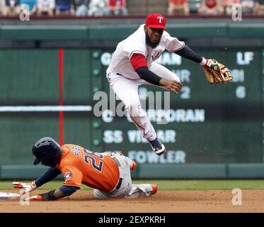 Texas Rangers shortstop Elvis Andrus (1) leaps over Houston Astros L.J. Hoes  (28) after making the throw to first to turn a double play in the second  inning at Globe Life Park