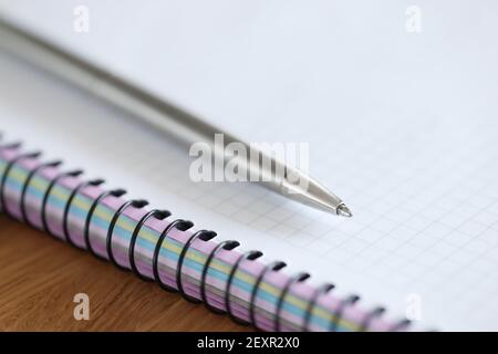 Metal ballpoint pen lying on blank notebook closeup Stock Photo