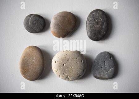 Six pebbles on white background. Stock Photo