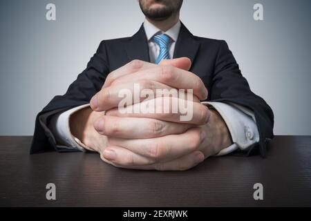 Sitting businessman with clasped hands. Negotiation and dealing concept. Stock Photo