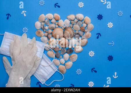 shells form of heart with a medical mask and gloves on a blue background. layout Stock Photo