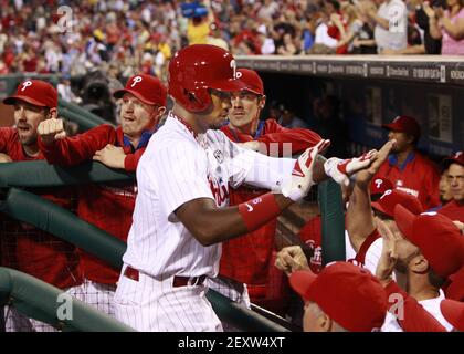 Philadelphia Phillies' Domonic Brown is congratulated in the dugout after  scoring on a single hit by Jerad Eickhoff in the fourth inning of a  baseball game against the Miami Marlins, Friday, Aug.