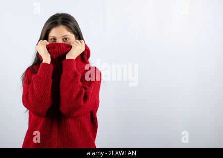 Portrait photo of a young woman model in red warm sweater covering Stock Photo