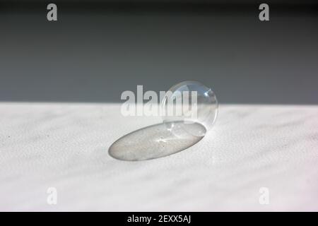 Soap bubble on the white table close-up. Contrasting shadow from a soap bubble.  Stock Photo