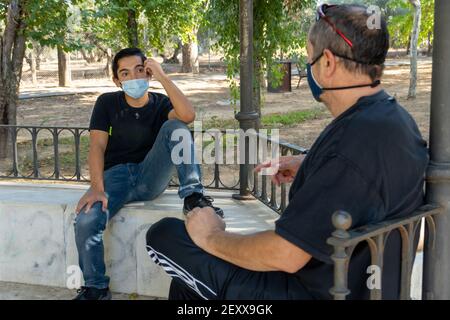 Stock photo of two men having fun in the park talking and looking at each other. Stock Photo