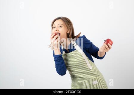 Image of young woman eating red apple on white background Stock Photo