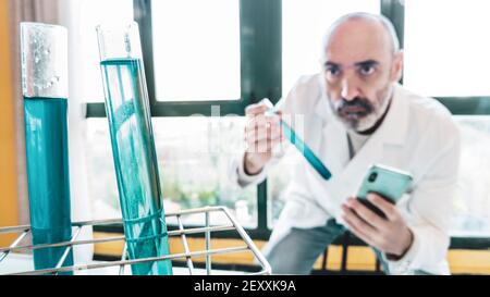 Test tubes with liquid and scientist with lab coat in a scientific laboratory. Basque Country, Spain, Europe. Stock Photo