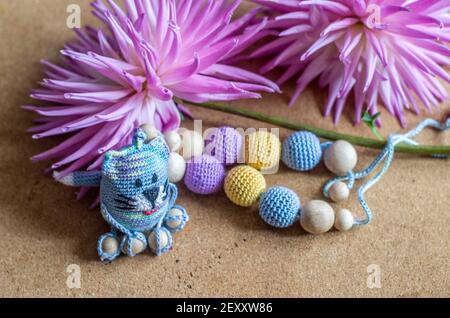 Necklace made from knitted beads and toys for the baby sitting in a sling. Knitted beads. Sling necklace. Stock Photo