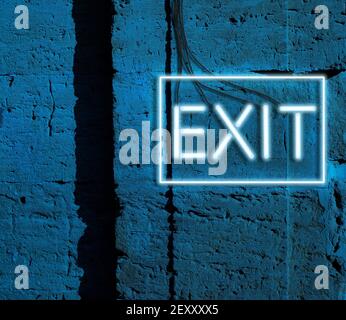 inscription exit from glowing neon blue lamps hangs on a brick wall, night Stock Photo