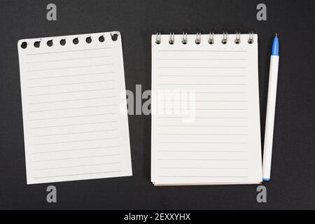 notebook with white sheets in a line on a black background, close up Stock Photo