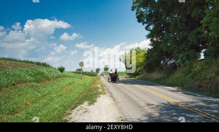 An Amish Couple in a Open Horse and Buggy on a Sunny Day Stock Photo