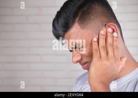 side view of young man suffering pain in ear  Stock Photo