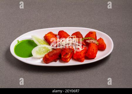 Paneer Tikka Kabab in red sauce - is an Indian dish made from pieces of cottage cheese marinated in spices Stock Photo