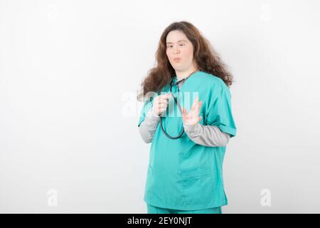 Picture of a young girl with down syndrome in green uniform holding stethoscope Stock Photo