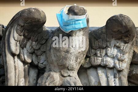 Potsdam, Germany. 03rd Mar, 2021. A surgical mask was tied around the beak of the stone eagle above the entrance to a front door in the city centre. Residents of the state capital can be tested for Corona (rapid antigen test) free of charge since 01.03.2021. The offer is part of the strategy 'Open, but safe'. Credit: Soeren Stache/dpa-Zentralbild/ZB/dpa/Alamy Live News Stock Photo