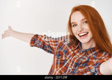 Happy relaxed hipster style girl with beanie searching for something in  handbag. Full body isolated on white background. Stock Photo