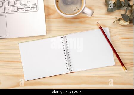 mockup notepad Notebook and coffee on wooden background, top view with space for text on workplace. top view. Blank sketchbook on wooden desk backgrou Stock Photo