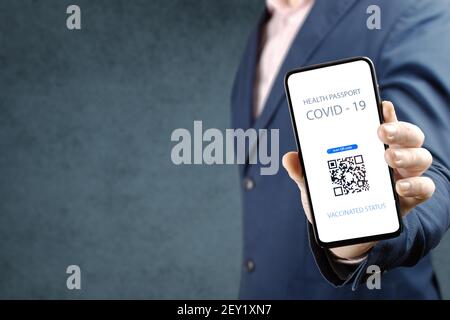 Covid-19 Health Passport. man holding cell phone with qr code covid 19 vaccination. man showing a health passport on a mobile phone, which indicates a Stock Photo