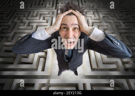 Young man is confused and lost in maze. 3D rendered illustration of maze. Stock Photo