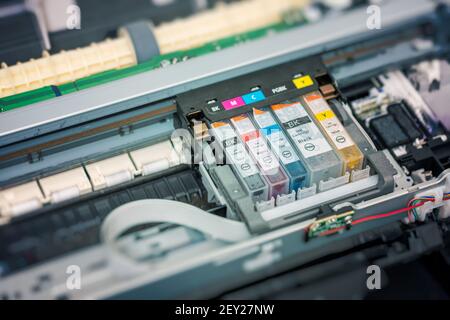 Replacement of CMYK set of ink cartridges in printer. Stock Photo