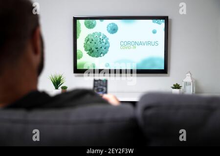 TV screen with covid-19 coronavirus news. Man in the sofa of his home watching a graphic of covid in the television. Control remote in the hand. Stock Photo