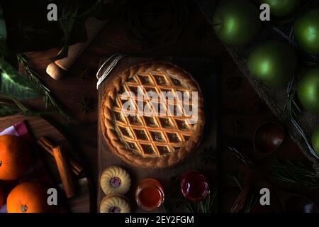 Freshly Baked apple pie in warm sunlight with utensils and a variety of ingredients. Stock Photo