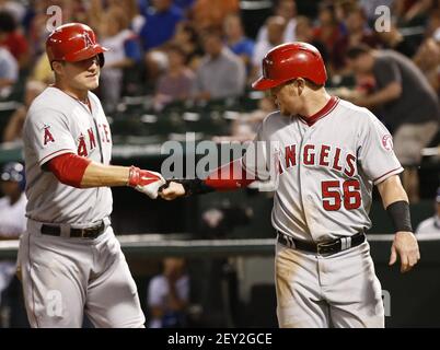 Texas Rangers' Kole Calhoun, left, and bench coach/offensive coordinator  Donnie Ecker, right, celebrate with Nathaniel Lowe (30) after Lowe hit a  solo home run against the Tampa Bay Rays during the fourth