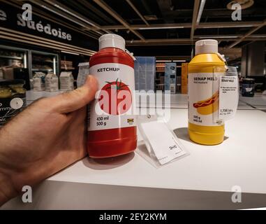 Paris, France - Jul 28, 2018: POV personal perspective male hand shopping inside Ikea store for delicious food - Tomato Ketchup and Senap Mild mustard with th price of 1 75 euros Stock Photo