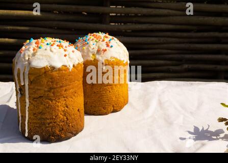 Easter cakes with a branch of a blossoming apple tree on a white tablecloth. Rustic style. Christian holiday concept. Horizontal orientation. Copy spa Stock Photo