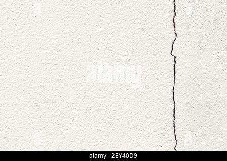 Cement white wall with a large crack copy space for text. Grunge concrete cement white wall with a crack background and texture. Stock Photo