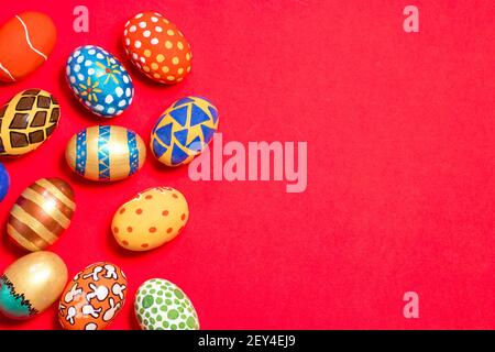Multicolored Easter eggs on a red background banner. Patterns and designs on colored dyed eggs on a greeting card with congratulations Stock Photo