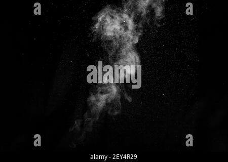 Abstract steam with dots of spray moves on a black background. Figured smoke can be used for design. Stock Photo