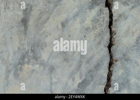 A house wall with a large crack. Grunge concrete cement wall with a crack in an industrial building. Stock Photo