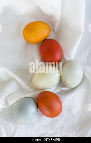 Naturally dyed orange, yellow, and blue Easter Eggs in a layflat Stock Photo