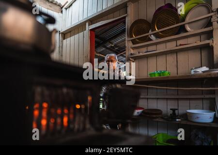 Senior woman in the door of the kitchen looking the stove Stock Photo