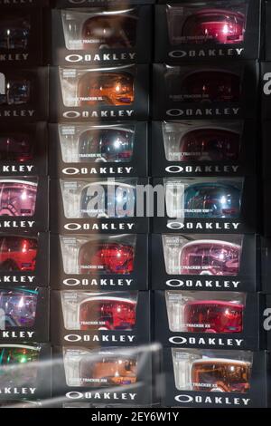 colorful oakley goggles in boxes in window of sports ski or snowboard shop or store at ski resort goggles reflecting in the sun shining through window Stock Photo