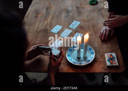 choose a card from the hands of a fortune teller. a woman tells fortunes during a magical ritual. belief in mysticism