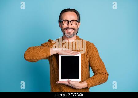 Photo portrait of happy smiling businessman showing copyspace touchscreen tablet isolated on bright blue color background Stock Photo