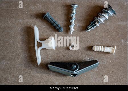 Various drywall anchors used in construction to hang objects on walls Stock Photo