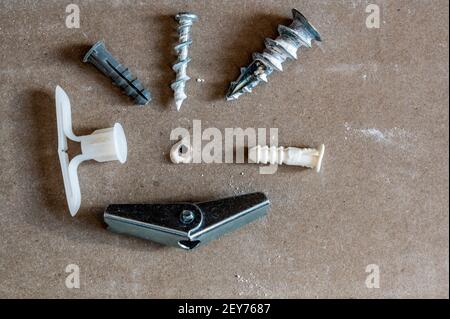 Various drywall anchors used in construction to hang objects on walls Stock Photo