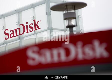 In this photo illustration the American flash memory manufacturer Sandisk  logo seen displayed on a smartphone with an economic stock exchange index  graph in the background Stock Photo - Alamy