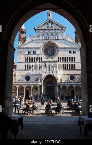 Ancient Cathedral of Cremona at beautiful market square Piazza Duomo in Cremona framed by an architectural arch, Lombardy, Italy Stock Photo