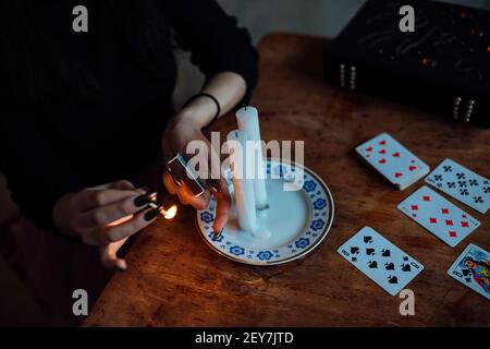 a fortune teller lights ritual candles to predict the future using cards Stock Photo