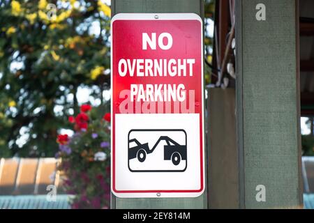 View of red sign No Overnight Parking with flowers in the background Stock Photo